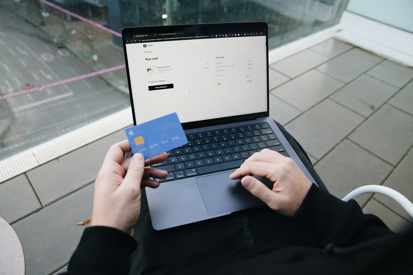 A customer checking out online with a card and laptop